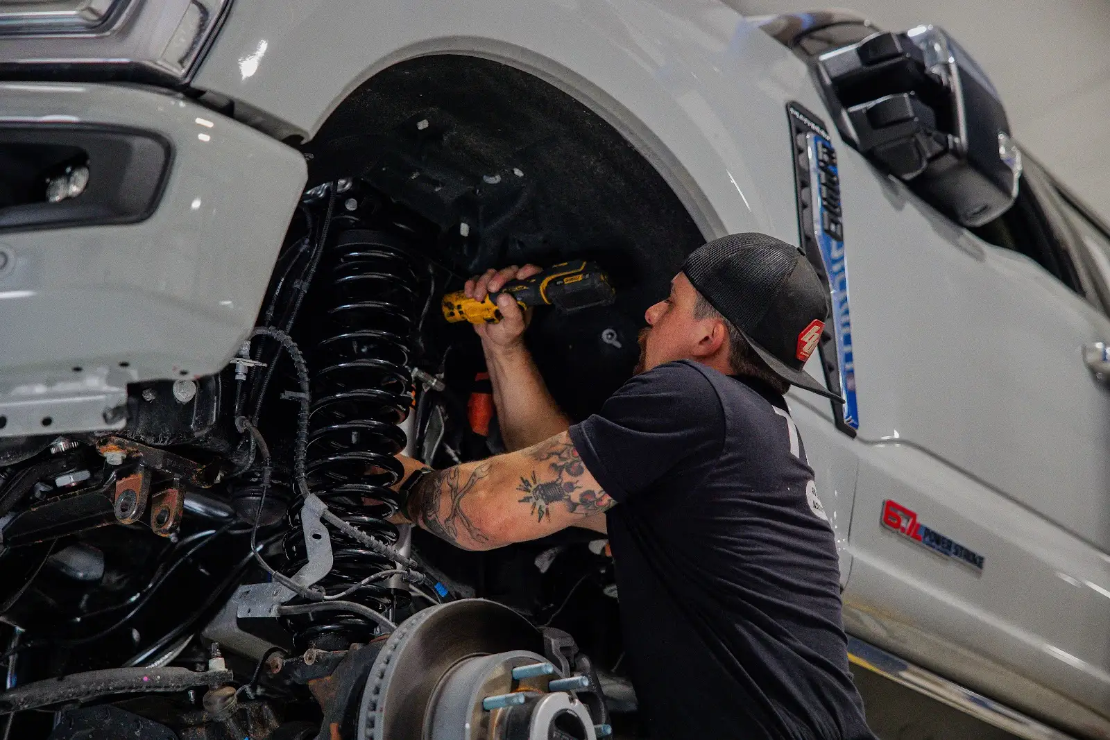Suspension Installation Mechanic installing suspension system on truck at THOR Off-Road shop
