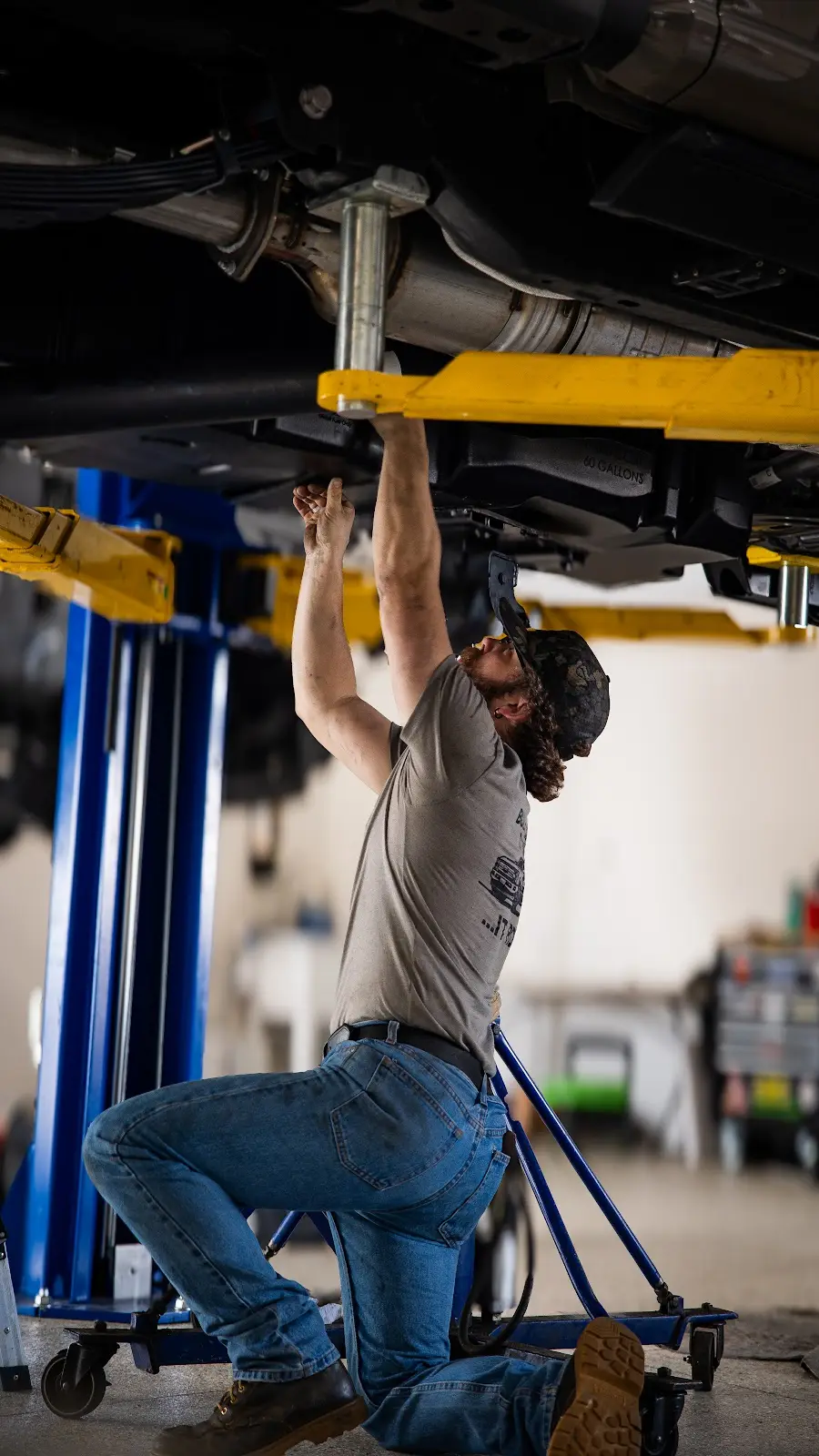 Professional Truck Installation THOR Off-Road mechanic working on truck suspension with hydraulic lift
